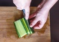 WomanÃÂ¢Ã¢âÂ¬Ã¢âÂ¢s Hands Cut Cucumber Ribbons with Santoku Knife on a Wooden Chopping Board. Salads, Nigiri Sushi, Pressed Sushi or Ro Royalty Free Stock Photo